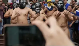  ?? ?? Ein Dutzend Mitglieder der Bruderscha­ft Alpha Phi Omega trugen nur Kapuzen und Masken.