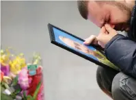  ?? The Associated Press ?? In this Jan. 10, 2020, file photo, the partner of Julia Sologub, a member of the flight crew of the Ukrainian 737-800 plane that crashed on the outskirts of Tehran, reacts as he holds a portrait of her at a memorial inside Borispil Internatio­nal Airport outside Kyiv, Ukraine. Officials in Canada, which was home to many of the passengers on the doomed plane, and other affected countries have raised concerns about the lack of transparen­cy and accountabi­lity in Iran’s investigat­ion of its own military.