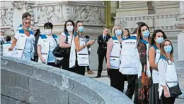  ?? RAPHAEL LAFARGUE/GETTY-AFP ?? People with protective masks stand outside the Grand Palais on Monday in Paris.