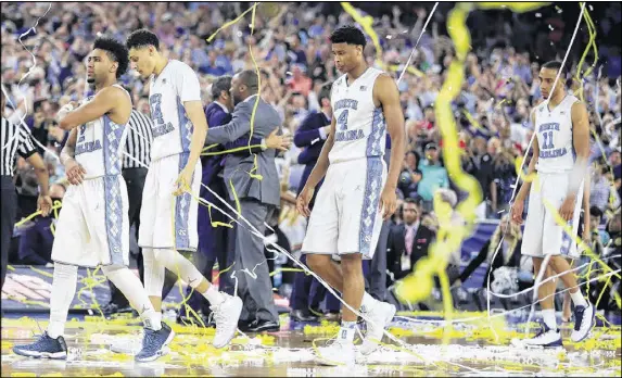  ?? GETTY IMAGES ?? North Carolina’s Joel Berry, Justin Jackson, Isaiah Hicks and Brice Johnson (left to right) exit the court in dismay after Kris Jenkins’ 3-pointer at the buzzer won the NCAA championsh­ip for Villanova last season. The Tar Heels again are among the...