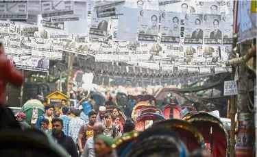  ?? — AFP ?? For your considerat­ion: Posters of the election candidates hanging over a busy street in Dhaka.