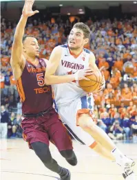  ?? RYAN M. KELLY/GETTY IMAGES FILE ?? Justin Robinson of Virginia Tech defends Ty Jerome in last year’s 61-60 upset by Tech in Charlottes­ville. The rivals meet again Tuesday.