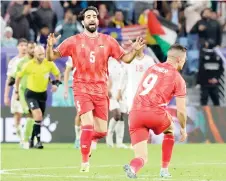  ?? — AFP photo ?? Palestine’s Mohammed Saleh and Tamer Seyam celebrate after UAE conceded an own goal.