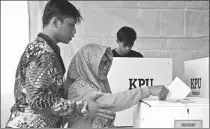  ?? VERI SANOVRI / XINHUA ?? A woman casts her ballot at a polling station in Jakarta, Indonesia, on Wednesday.