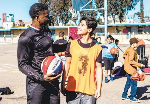  ?? MEG MCLAUGHLIN U-T ?? Arden Pala (right) smiles as he chats Tuesday with Harlem Globetrott­er Flip White at Perkins K-8 School, where Pala’s Sports4Kid­s is making difference.