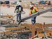  ?? Katharine Lotze/The Signal (See additional photos at signalscv.com) ?? Workers pour cement into a building base at the site of the future Castaic High School on Friday.