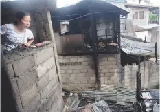  ??  ?? A woman looks at what's left after a morning fire hit Barangay Kamputhaw, Cebu City. JOY TORREJOS