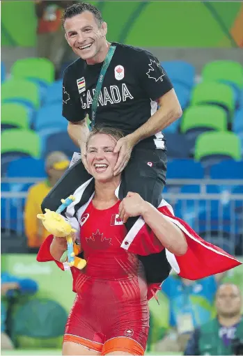  ?? DAVE ABEL ?? Erica Wiebe carries her coach Paul Ragusa after beating Guzel Manyurova of Kazakhstan in the women’s freestyle wrestling 75-kg gold medal match Thursday. “I just went out there and wrestled. I had fun today.”