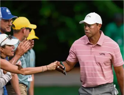 ?? ASHLEY LANDIS/ASSOCIATED PRESS ?? Tiger Woods, interactin­g with fans on No. 6, could only finish 13 holes before darkness fell.