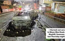  ??  ?? > Burned-out cars in Waun-Wen Road, Mayhill, Swansea, last Thursday night