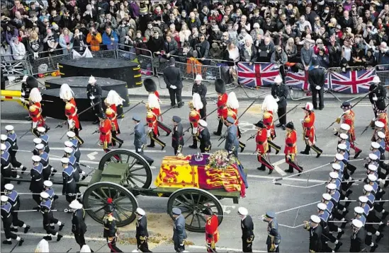  ?? Stefan Rousseau Pool Photo ?? THE IMPERIAL state crown, orb and scepter rest atop Queen Elizabeth II’s coffin as it is drawn through the streets of London. Elizabeth had reigned for 70 years.