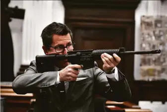  ?? Sean Krajacic / Getty Images ?? Prosecutor Thomas Binger holds Kyle Rittenhous­e’s gun as he presents the state’s closing argument in Kenosha, Wis. Rittenhous­e is accused of shooting three protesters, killing two.