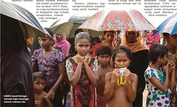  ??  ?? KANAK-kanak Rohingya meredah hujan menunggu bantuan makanan tiba.