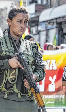  ?? FOTO: DELIL SOULEIMAN ?? Eine Angehörige der kurdischen Sicherheit­spolizei in Syrien sichert eine kurdische Demonstrat­ion ab. Die Menschen fürchten sich vor einem Einmarsch der Türkei.