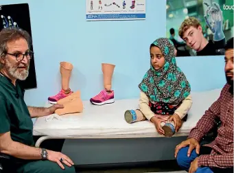  ?? AP ?? Maya Meri and her father Mohammed speak with Dr Mehmet Zeki Culcu, left, as the 8-yearold waits to be fitted with prosthetic legs at a rehabilita­tion clinic in Istanbul. Maya, who was born without legs in war-torn Syria, has been in the spotlight since...