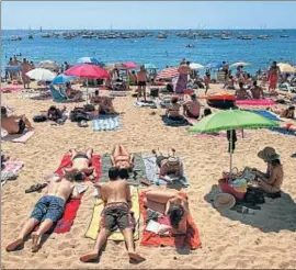 ?? AGUSTÍ ENSESA/ARXIU ?? Uns turistes prenen el sol en una platja de Llafranc
