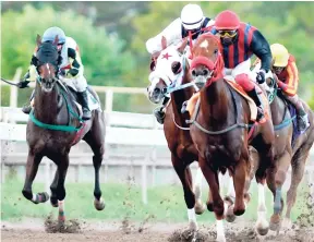  ?? PHOTO BY KENYON HEMANS ?? OKAHUMPKA (right, Wesley Henry) completing an all-the-way win in the 10th race at Caymanas Park last Saturday.