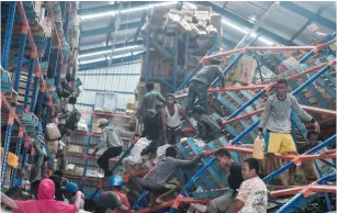  ?? (Antara Foto/Muhammad Adimaja/ Reuters) ?? EARTHQUAKE AND TSUNAMI victims look for goods to use in a warehouse in Palu, Indonesia, yesterday.