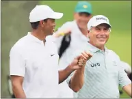  ?? Curtis Compton / TNS ?? Tiger Woods gives Fred Couples a fist bump as they share a laugh on the third hole during thier practice round for the Masters at Augusta National Golf Club on Wednesday in Augusta, Ga.