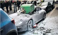  ??  ?? A vandalised Porsche in Paris was one consequenc­e of ‘yellow vest’ protests and clashes between Right and Left-wing demonstrat­ors during a 13th consecutiv­e weekend of unrest in France