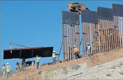  ?? / R. B. (AP) ?? Varios operarios trabajan en la construcci­ón del muro que separa a EE UU de México en Tijuana.