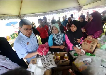  ?? — Bernama photo ?? Saifuddin (front left) chats with the traders and the buyers at one of the stalls.