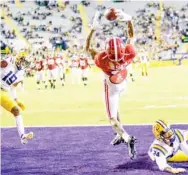  ??  ?? Alabama wide receiver Devonta Smith (6) reaches up to make a touchdown grab against LSU cornerback Derek Stingley Jr. (24) during the first half of Saturday night’s game. (Photo by Matthew Hinton, AP)