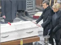  ?? AP PHOTO ?? French President Emmanuel Macron puts his hands on the coffin of French rocker Johnny Hallyday during the funeral service at the Madeleine churchwhil­e his wife Brigitte Macron looks on, in Paris, France, Saturday.