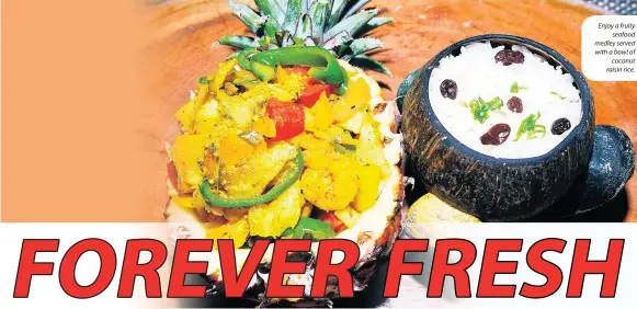  ??  ?? Enjoy a fruity seafood medley served with a bowl of coconut raisin rice.