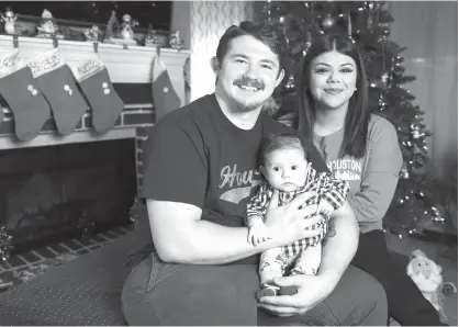  ?? Yi-Chin Lee/Houston Chronicle via AP ?? Michael Cassidy, 26, and his fiancee, Alexis Garcia, 22, pose for a photo with their 2-month-old son, Azrael Cassidy, on Dec. 10, 2017, in Houston. Ejected from his motorcycle after his tires hit a patch of oil, Michael Cassidy landed on a fire hydrant...