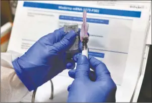  ?? The Associated Press ?? VACCINE UPDATE: Nurse Kathe Olmstead prepares a shot on July 27 that is part of a possible
COVID-19 vaccine, developed by the National Institutes of Health and Moderna Inc., in Binghamton, N.Y. The Food and Drug Administra­tion laid out updated safety standards Tuesday for makers of
COVID-19 vaccines after the White House blocked their formal release, the latest political tug-of-war between the Trump administra­tion and the government’s public health scientists.