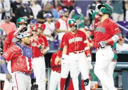  ?? AL DIAZ adiaz@miamiheral­d.com ?? Mexico’s Isaac Paredes, right, who hit a solo homer in the second inning, drove in three runs in Friday’s come-from-behind win against Puerto Rico at the World Baseball Classic.