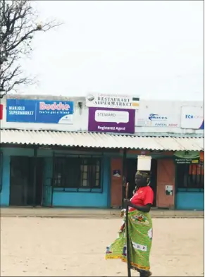  ??  ?? A woman passes through Manjolo shops