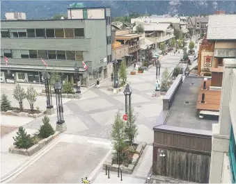  ??  ?? Bear Street in Banff's downtown is now a shared space where vehicles, cyclists and pedestrian­s are “equal users.”