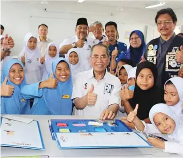  ??  ?? Wan Junaidi (seated centre) is seen with pupils of SK Tanjung Bako and other officials at the new block. Dr Hazland is seen standing at right.