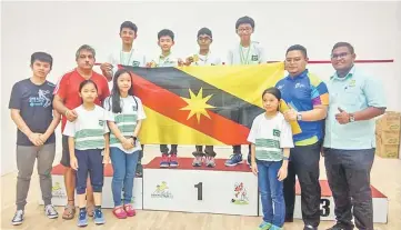  ??  ?? Harith (top left) with teammates, coaches and officials. Also seen is SRAM developmen­t officer Al Ardy Ally (right).