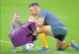  ?? AFP ?? ■ Australia's scrum-half Nic White plays with a child at Oita Stadium on Friday.