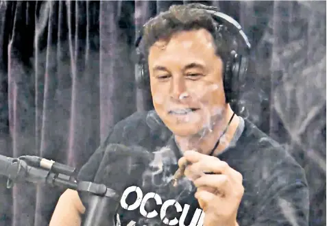 ??  ?? Elon Musk, the billionair­e entreprene­ur, smoking cannabis live on the internet in an interview with Joe Rogan, the comedian, in which he said it was like a cup of coffee in reverse