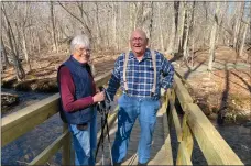  ?? STEVE FAGIN ?? Karen and Keith Parkinson, longtime supporters of a trail that would connect Preston to Groton, stand on a bridge that volunteers built over Joe Clark Brook in Ledyard. Keith is a past president of the TriTown Trail Associatio­n; his wife is the current president.
