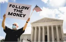  ?? Andrew Harnik / Associated Press ?? A man protests outside the Supreme Court after it ruled last month that President Trump must release his tax records.