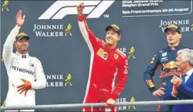  ?? REUTERS ?? Ferrari’s Sebastian Vettel (C) celebrates while Lewis Hamilton and Max Verstappen look on.