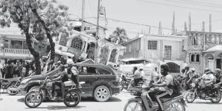  ?? Delot Jean / Associated Press ?? Petit Pas Hotel crumbles after a powerful earthquake in Les Cayes on Saturday. Tropical Storm Grace also threatens the island nation.