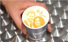  ??  ?? An image of Prince Harry and Meghan is seen on top of a cup of coffee being sold ahead of their forthcomin­g wedding in Windsor, on Wednesday. — Reuters photo