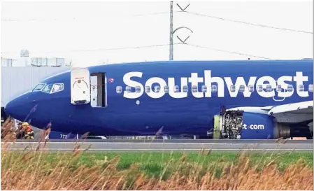  ?? — Reuters ?? Safe landing: Emergency personnel monitoring the damaged engine of Southwest Airlines Flight 1380, which diverted to the Philadelph­ia Internatio­nal Airport after the engine damage.