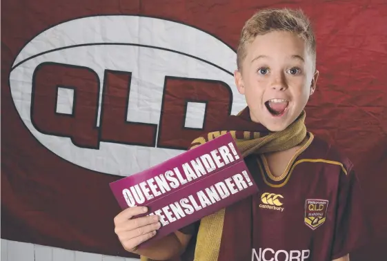  ??  ?? Maroons fan Joey Sankey with Queensland­er bumper stickers which are available free with the purchase of Saturday’s Gold Coast Bulletin. Picture: STEVE HOLLAND