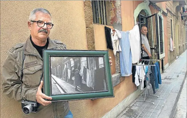  ?? KIM MANRESA ?? El cronista del vecindario. Vicens Forner, con una de sus fotografía­s, en la calle Sant Telm, la prueba de que no todo ha cambiado en este barrio