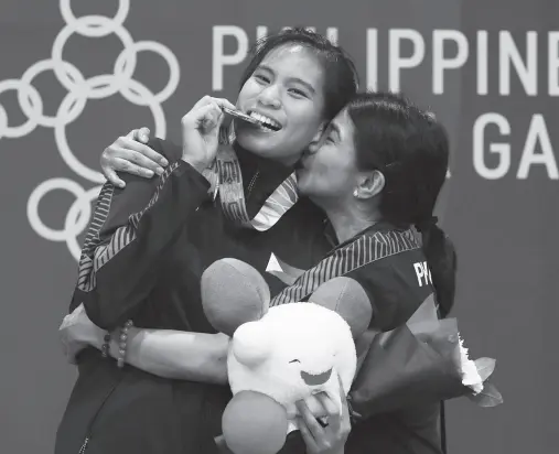  ?? PNA photo ?? SWEET KISS. Karateka Jamie Christine Lim of the Philippine­s gets a kiss from her mother, former Pag-IBIG Fund president and chief executive officer Darlene Berberabe, during the awarding ceremony in the 30th Southeast Asian Games at the World Trade Center in Pasay City. Lim clinched the gold in the women’s kumite +61 kilogram.