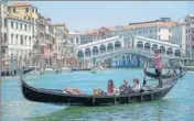  ?? BLOOMBERG ?? Tourists ride a gondola near the Rialto Bridge in Venice.