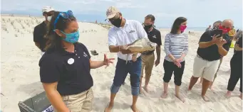  ??  ?? Kate Shaffer, rehabilita­tion manager at the National Aquarium, left, introduces Muenster, a Kemp’s ridley sea turtle, held by Maryland Lt. Gov. Boyd Rutherford. The turtle was released after being nursed back to health.