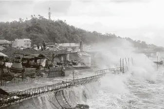  ?? Simvale Sayat / Associated Press ?? Strong waves batter the coastline of Catbalogan in eastern Philippine­s after a strong typhoon slammed ashore Thursday. Tens of thousands of people were evacuated.